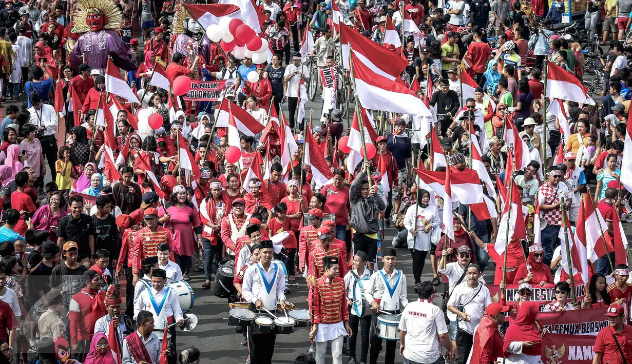 Peserta mengibarkan bendera merah putih saat Karnaval Cinta Budaya NKRI di kawasan MH Thamrin, Jakarta, Minggu (20/11). Karnaval berbentuk parade budaya ini menghadirkan budaya nusantara, dari Reog Ponorogo hingga drum Band (Liputan6.com/Faizal Fanani)