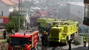 Petugas pemadam kebakaran tiba di lokasi jatuhnya sebuah pesawat kecil di dekat pasar swalayan daerah permukiman di Tires, Portugal, Senin (17/4). Lima orang tewas akibat pesawat itu jatuh menimpa truk dan menimbulkan kebakaran. (andre nobre/AFP)