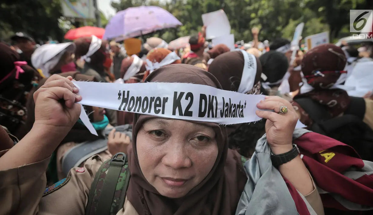 Pegawai honorer DKI Jakarta menggelar demo di Balai Kota, Jakarta, Rabu (26/9). Massa mengenakan seragam pramuka dan membawa sejumlah poster aspirasi. (Liputan6.com/Faizal Fanani)