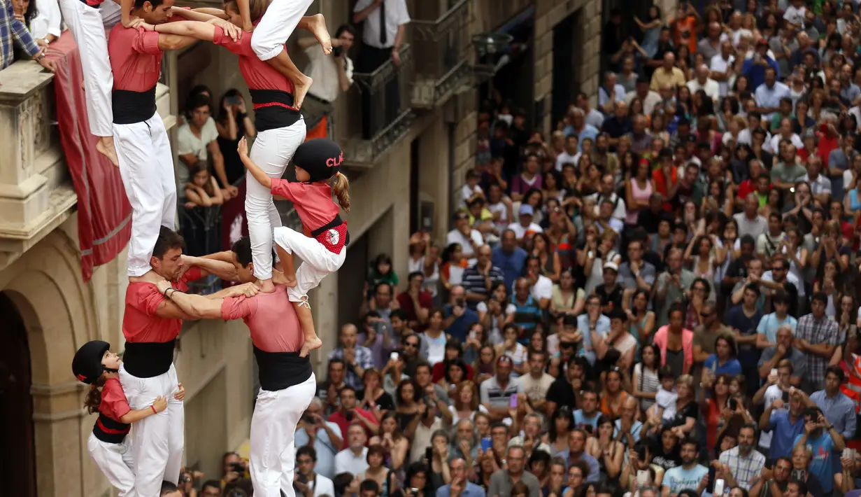 Anak-anak kecil juga terlihat mengikuti kompetisi menara manusia dalam festival Sant Joan di Spanyol, Selasa (24/6/14). (REUTERS/Albert Gea)
