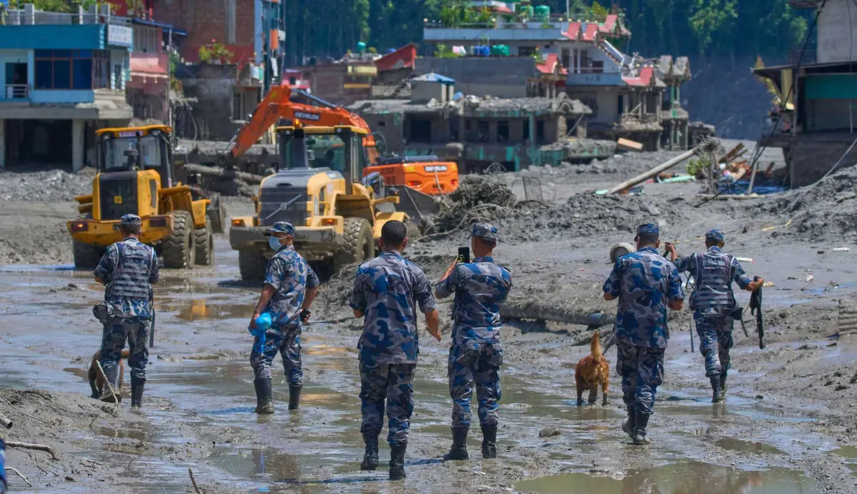 Polisi Nepal mengawasi saat alat berat menyingkirkan puing-puing akibat banjir bandang di distrik Nuwakot, Nepal, Kamis, 27 Agustus 2026. (Foto AP/Niranjan Shrestha)