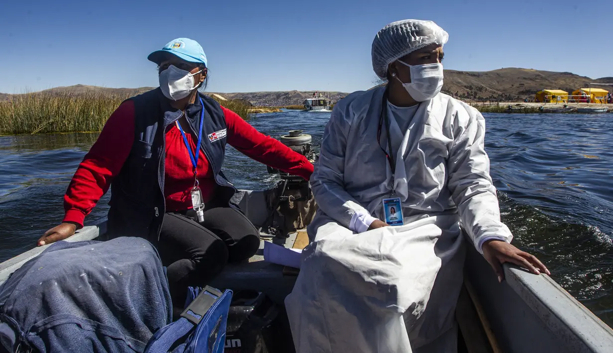 Petugas kesehatan diantar ke pulau Uros untuk menyuntik warga dengan vaksin COVID-19 Sinopharm, di danau Titicaca di Puno, Peru, pada 7 Juli 2021. Peru memulai vaksinasi COVID-19 untuk ratusan penduduk asli yang tinggal di pulau terapung Uros, di Danau Titicaca. (Carlos MAMANI / AFP)