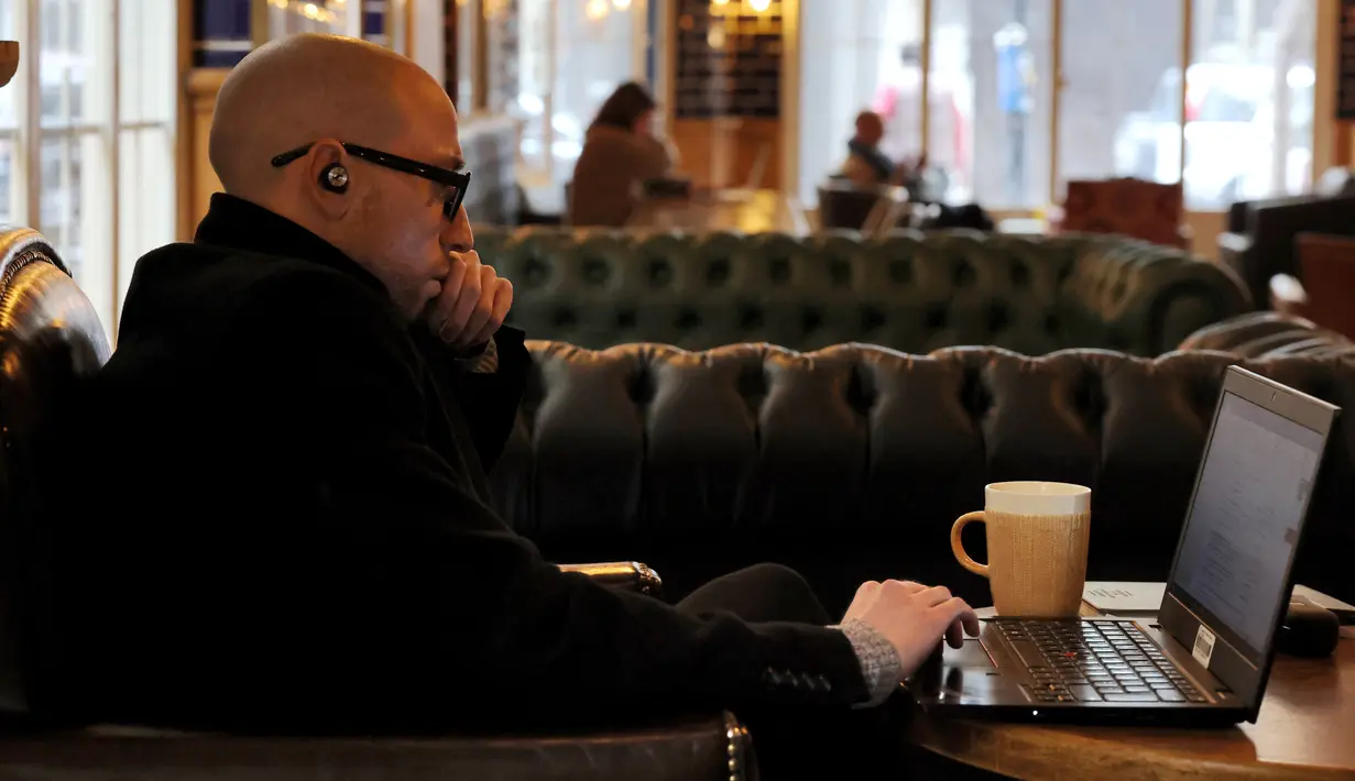 Seorang pria duduk dengan laptopnya di sebuah kafe di Beirut pada 14 Januari 2022. Kafe-kafe Beirut sekarang berfungsi sebagai tempat kerja pengganti bagi orang-orang yang bergulat dengan kekurangan listrik dan pemutusan internet yang berasal dari krisis ekonomi. (JOSEPH EID / AFP)