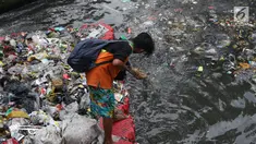 Salah satu petugas UPK Badan Air Dinas Lingkungan Hidup DKI Jakarta mengangkut ceceran sampah di Kali Cideng, Jakarta, Jumat (9/11). Pembersihan untuk mencegah terjadinya penumpukan sampah saat musim hujan di Jakarta. (Liputan6.com/Helmi Fithriansyah)
