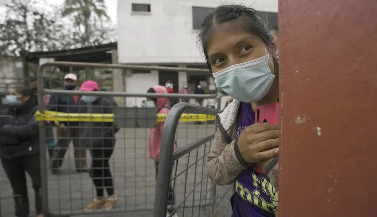 Seorang wanita menunggu ibunya yang mendapatkan vaksin COVID-19 di Pillaro, Kamis (8/7/2021). Ekuador meningkatkan vaksinasi menjadi 200.000 orang per hari dalam upaya untuk memastikan 9 juta warga divaksinasi dalam 100 hari pertama pemerintahan Presiden Guillermo Lasso. (AP Photo/Dolores Ochoa)