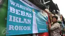 Siswa SMP N 104 Jakarta memasang banner di salah satu warung di kawasan Mampang Prapatan, Jakarta, Kamis (5/11). Aksi ini sebagai bentuk kesadaran tentang ancaman adiksi rokok terhadap anak-anak di sekolah melalui iklan (Liputan6.com/Gempur M Surya)