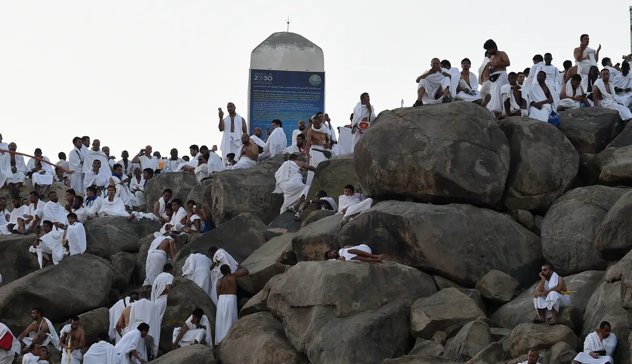 Jemaah haji mengunjungi bukit Jabal Rahmah di Padang Arafah, sebelah tenggara kota suci Makkah, Arab Saudi, Sabtu (10/8/2019). Menjelang Wukuf Arafah, Jabal Rahma yang terletak di Padang Arafah banyak dikunjungi peziarah haji. (FETHI BELAID / AFP)
