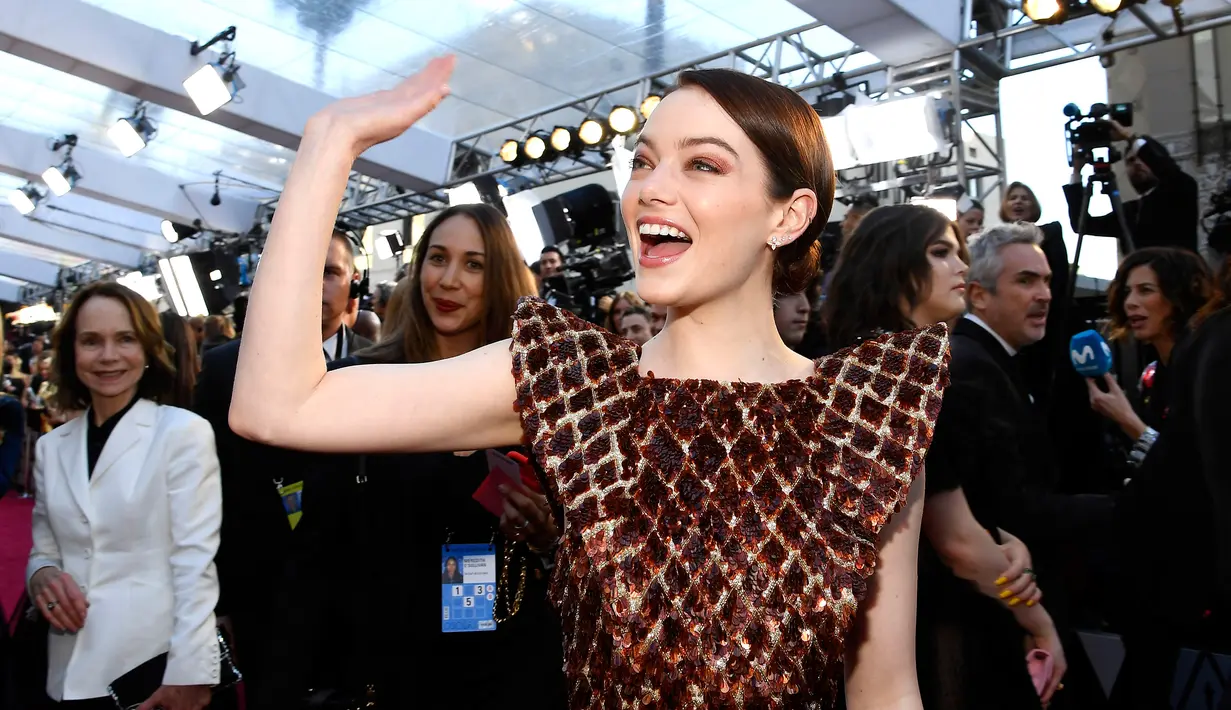 Aktris Emma Stone menyapa fans saat tiba menghadiri perhelatan Piala Oscar 2019 di Teater Dolby di Los Angeles, AS (24/2). Emma Stone hadir untuk melihat nominasi filmnya The Favorite di Piala Oscar. (AFP Photo/Kevork Djansezian)