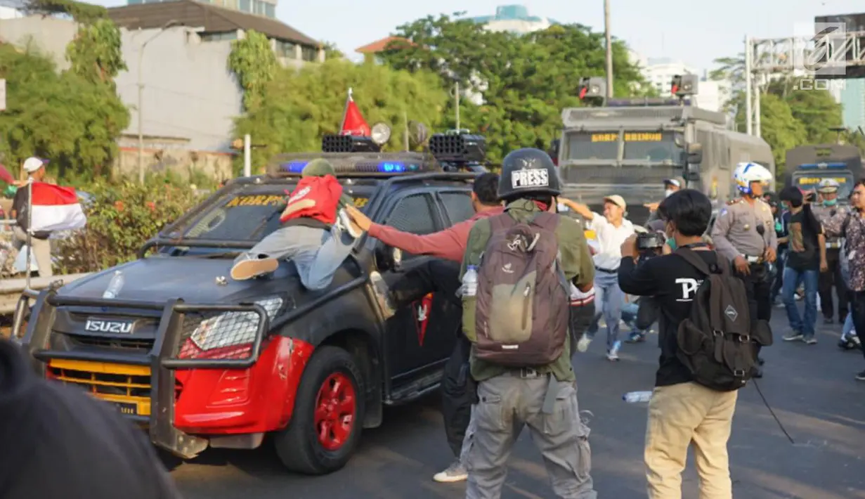 Massa pelajar menyerang kendaraan milik kepolisian yang melintas saat aksi unjuk rasa  di sekitar kawasan DPR RI, Jakarta, Senin (30/9/2019). Sempat terjadi kericuhan akibat peristiwa tersebut hingga menyebabkan jalan tol ditutup. (Liputan6.com/Immanuel Antonius)