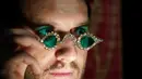 Seorang anggota staf mengenakan kacamata Mughal dengan lensa berlian, dalam bingkai berlian, di Sotheby's, di London, Jumat (22/10/2021). Kacamata ini akan lebih dulu dipamerkan ke publik dengan berkeliling ke New York, Hong Kong, dan London. (AP Photo/Alberto Pezzali)