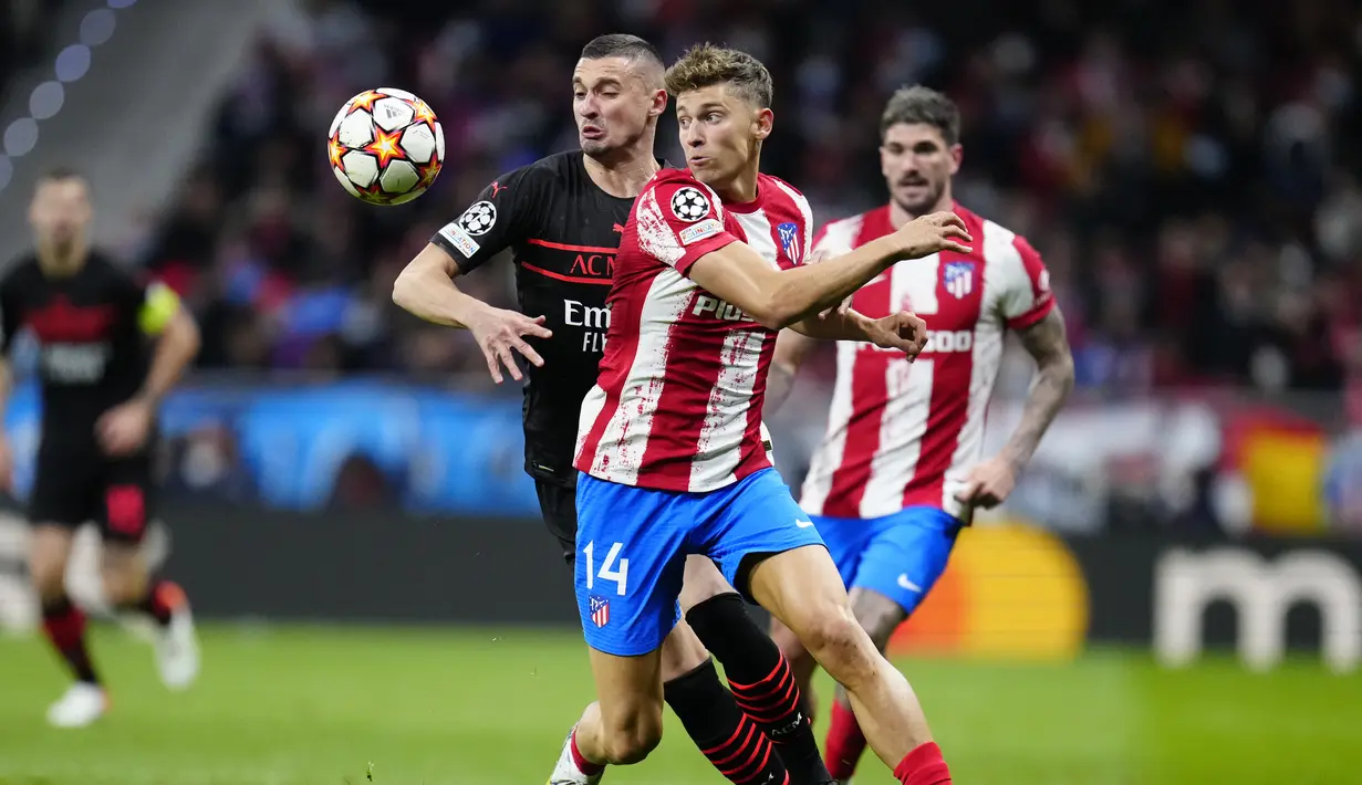 Gelandang AC Milan Rade Krunic berebut bola dengan gelandang Atletico Madrid Marcos Llorente pada laga kelima Grup B Liga Champions 2021/2022 di Stadion Wanda Metropolitano, Kamis (25/11/2021) dini hari WIB. AC Milan menaklukkan tuan rumah Atletico Madrid 1-0. (AP Photo/Manu Fernandez)