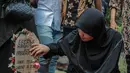 Istri mendiang George Mustafa Taka, Desty Amalia melihat nisan suaminya usai pemakaman  di Komplek Pemakaman Kempo, Jatiwaringin, Pondok Gede, Jakarta, Jumat (2/10). (Liputan6.com/Faizal Fanani)