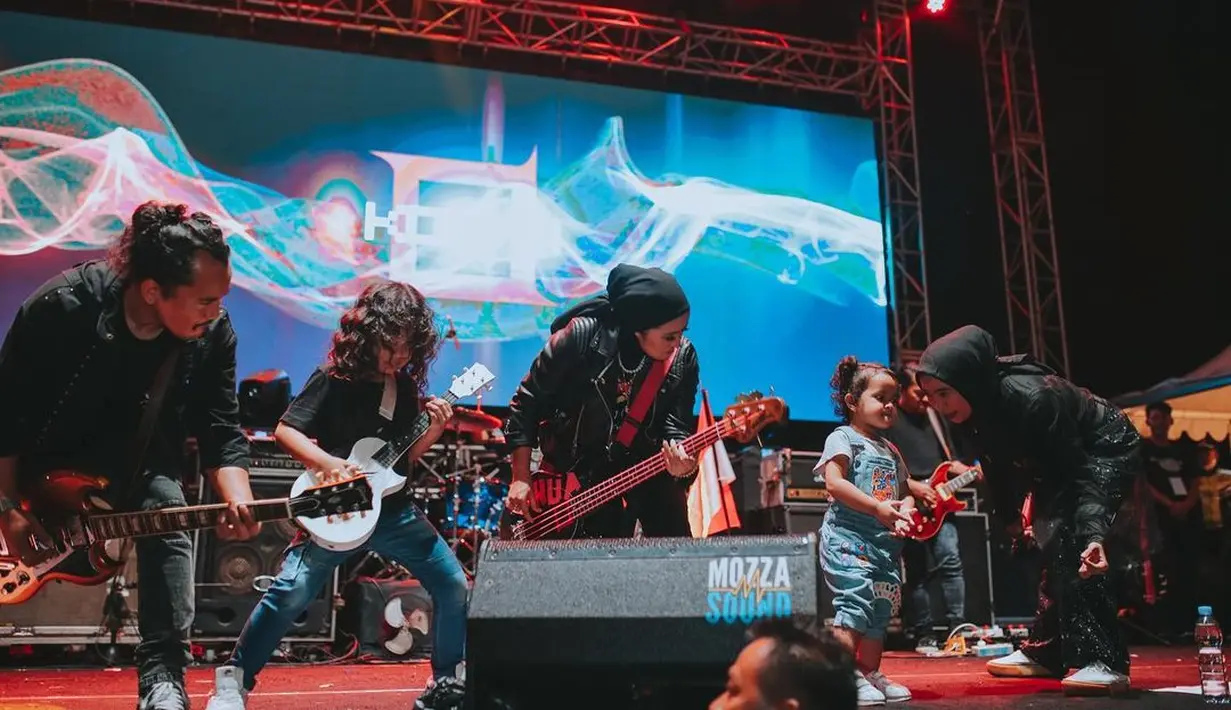 Meski mengenakan hijab, Chua Kotak tetap tampil bak rocker saat manggung sambil memainkan bass nya. (Foto: Instagram/@chuakotak)