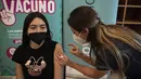 Petugas kesehatan menyuntikan vaksin COVID-19 Pfizer BioNTech kepada seorang anak di pusat vaksinasi di Santiago, Chile, Rabu (23/6/2021). Chile mulai memvaksinasi anak-anak dari usia 12 tahun, sebagai salah upaya untuk memutus rantai penyebaran infeksi virus Corona. (MARTIN BERNETTI/AFP)