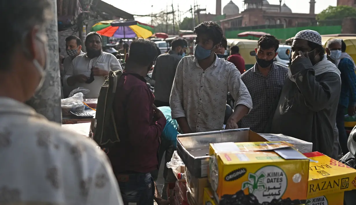 Orang-orang membeli kurma di sepanjang jalan menjelang bulan suci Ramadhan di Delhi, India pada Selasa (13/4/2021). Kurma sangat identik dengan bulan Ramadhan, karena buah yang satu ini kerap dijadikan pengisi menu sahur dan berbuka puasa. (Sajjad HUSSAIN / AFP)