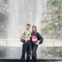 Kala liburan bareng di Singapura, Sabrina dan Nada kompak padukan black high waisted jeans dengan crop top. Gaya keduanya edgy abis! @sabrinachairunnisa_.