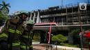 Petugas pemadam kebakaran melintas di depan gedung utama Kejaksaan Agung yang terbakar di Jakarta, Minggu (23/8/2020). Kebakaran yang berawal sejak Sabtu (22/8) malam itu, baru bisa dikuasai pagi ini, Minggu (23/8). (Liputan6.com/Faizal Fanani)