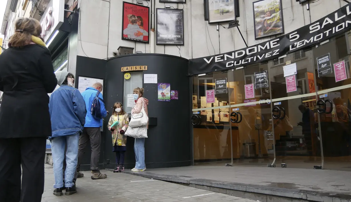Orang-orang berbaris di luar bioskop di Brussel, Rabu (29/12/2021). Otoritas Belgia mengizinkan pembukaan kembali bioskop, teater, dan ruang konser setelah pengadilan memenangkan gugatan dari sektor budaya terhadap penutupan venue-venue budaya. (AP Photo/Sylvain Plazy)