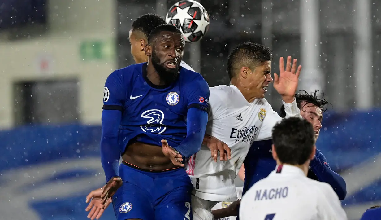 Bek Chelsea, Antonio Ruediger (kiri) dan bek Real Madrid, Raphael Varane melompat saat berebut pada leg pertama semifinal Liga Champions di Stadion Alfredo Di Stefano, Rabu (28/4) dini hari WIB.  Real Madrid hanya mampu bermain imbang 1-1 melawan Chelsea. (JAVIER SORIANO / AFP)