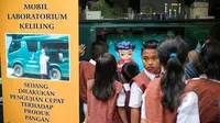 Sejumlah siswa melihat laboratorium keliling milik BPOM saat melakukan sidak untuk mengetahui kandungan makanan berbahaya pada jajanan anak-anak di SDN 15 Rawamangun, Jakarta, Senin (13/4/2015). (Liutan6.com/Faizal Fanani)