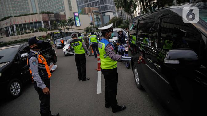 Petugas gabungan dari Polisi, Dishub, dan Satpol PP mengimbau pengguna kendaraan saat melakukan Pengawasan Pelaksanaan PSBB di Bundaran HI, Jakarta, Senin (13/4/2020). Dalam pengawasan tersebut petugas mengimbau masyarakat untuk menggunakan masker saat berpergian. (Liputan6.com/Faizal Fanani)