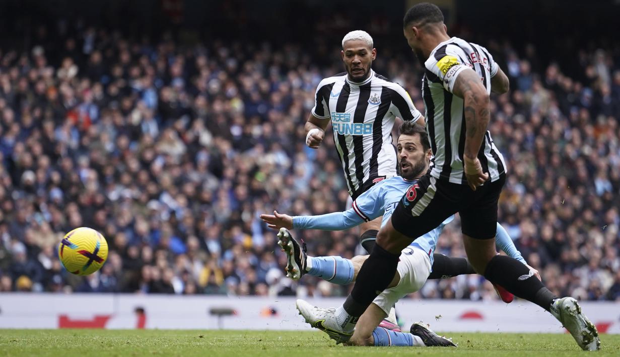 Gelandang Manchester City, Bernardo Silva (tengah) melepaskan tendangan yang berbuah gol kedua timnya ke gawang Newcastle United pada laga lanjutan Liga Inggris 2022/2023 di Etihad Stadium, Manchester, Sabtu (4/3/2023) malam WIB. (AP Photo/Dave Thompson)