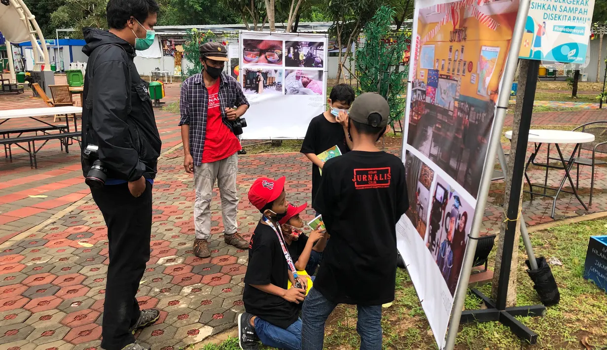 Komunitas “Kelas Jurnalis Cilik” dipandu pewarta foto mengikuti kegiatan tur pameran fotografi bertema 'Ragam Cerita Ibu Kota Sebelum dan Saat Pandemi COVID-19' di Thamrin 10, Jakarta, Minggu (6/12/2020). Pameran tersebut berlangsung hingga 13 Desember 2020. (Liputan6.com/Immanuel Antonius)