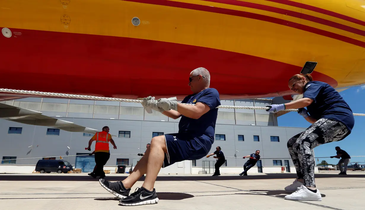 Anggota tim sekuat-tenaga untuk menarik pesawat DHL Boeing 757 sejauh 20 meter di Safi Aviation Park, Malta pada 1 Mei 2019. Kegiatan tarik pesawat tersebut merupakan rangkaian dalam rangka untuk penggalangan dana amal. (REUTERS/Darrin Zammit Lupi)