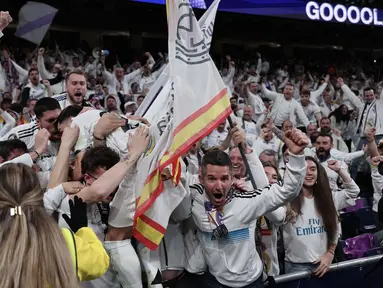 Penyerang Real Madrid, Brahim Diaz melompat ke tribun penonton setelah mencetak gol kedua bagi timnya pada pertandingan leg pertama 16 besar Liga Champions 2024/2025 melawan Atletico de Madrid di stadion Santiago Bernabeu, Madrid, pada 4 Maret 2025 waktu setempat atau Rabu (5/3/2025) dini hari WIB. (Thomas COEX/AFP)