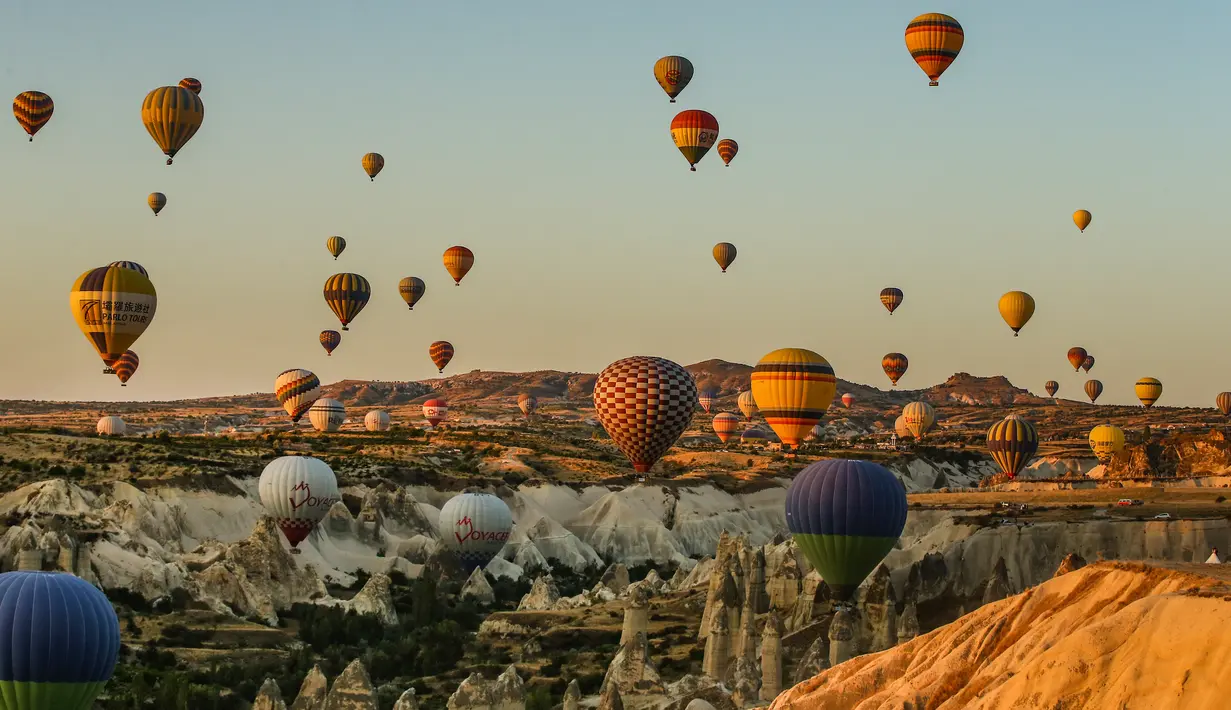Balon udara membawa wisatawan naik ke langit saat matahari terbit di Kapadokia, Turki, Selasa (7/8). Kapadokia memiliki sejumlah keajaiban alam, khususnya Cerobong Peri (Fairy Chimney). (AP Photo/Emrah Gurel)