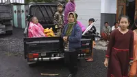 Wanita Indonesia duduk di belakang truk saat mereka bersiap untuk mengungsi dari rumah mereka setelah letusan Gunung Semeru di Lumajang, Jawa Timur, Indonesia, Selasa (1/12/2020). (AP Photo)