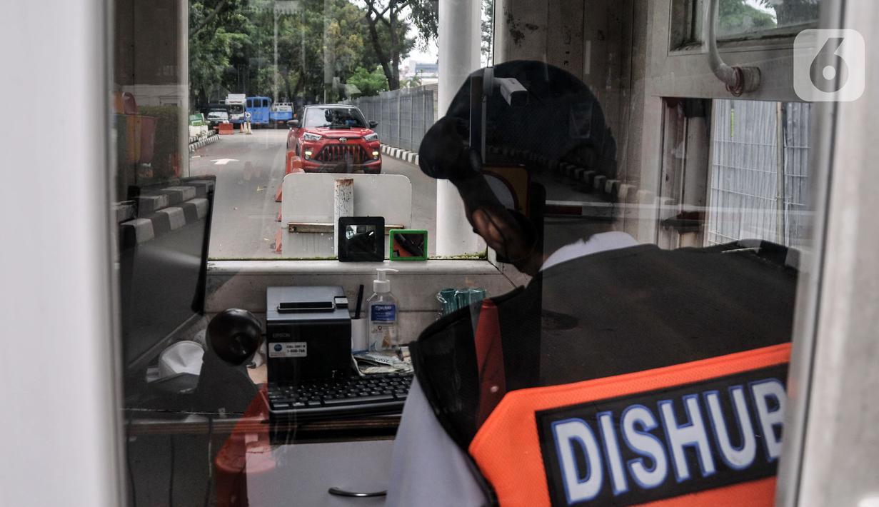 Petugas parkir bekerja dalam ruangannya di IRTI Monas, Jakarta, Rabu (15/2/2023). Penerapan tarif disinsentif (tarif parkir tertinggi) berdasarkan Pergub Provinsi DKI Jakarta Nomor 66 Tahun 2020 Tentang Uji Emisi Gas Buang Kendaraan Bermotor. (merdeka.com/Iqbal S. Nugroho)