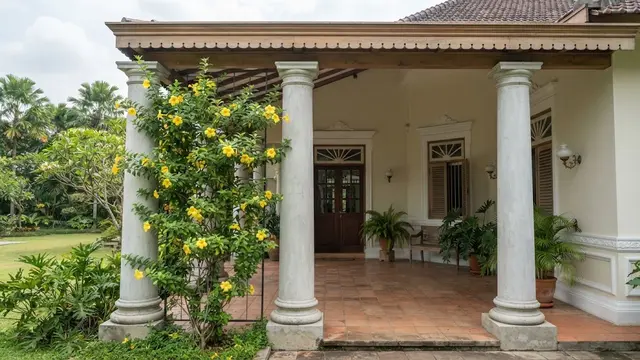 Teras Klasik Kolonial dengan Kolom Beton dan Bunga Alamanda