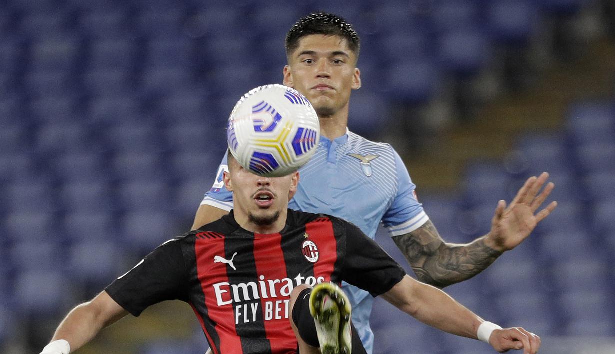 Gelandang AC Milan, Ismael Bennacer (depan) mengontrol bola dibayangi Lazio, Joaquin Correa dalam laga lanjutan Liga Italia 2020/2021 pekan ke-33 di Olimpico Stadium, Roma, Senin (26/4/2021). AC Milan kalah 0-3 dari Lazio. (AP/Gregorio Borgia)