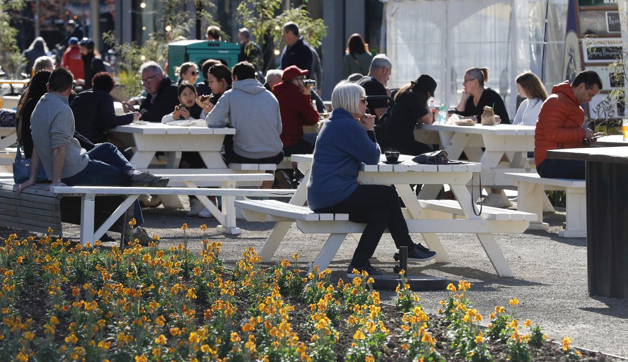 <p>Pelanggan menikmati makan siang di bawah sinar matahari di Pasar Riverside di Christchurch, Selandia Baru pada Minggu (9/8/2020). Selandia Baru pada Minggu kemarin telah berhasil melewati 100 hari tanpa merekam kasus Virus Corona COVID-19 yang ditularkan secara lokal. (AP Photo/Mark Baker)</p>
