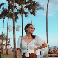 Kacamata hitam jadi salah satu fashion items yang tak boleh ketinggalan untuk melindungi silaunya terik matahari. (Instagram/amandarawles).