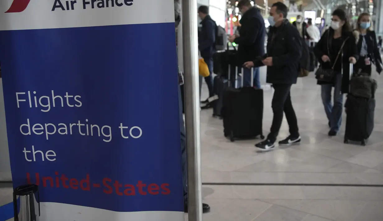Pelancong untuk Amerika Serikat tiba di meja Air France di bandara Charles de Gaulle, utara Paris, Senin (8/11/2021). Anggota keluarga akan terhubung kembali dengan orang yang dicintai setelah lebih dari satu setengah tahun terpisah karena pandemi. (Foto AP/Christophe Ena)