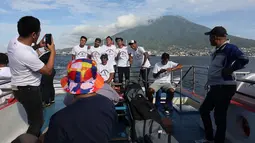 Sejumlah pemain dan staf Malut United berfoto bersama di atas kapal ferry dengan latar belakang gunung ketika menuju Tidore, Maluku Utara. (Bola.com/Okie Prabhowo)