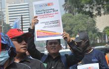 FOTO: Panas-Panasan Demo di Patung Kuda, Massa Buruh Tuntut Penghentian Ancaman PHK Besar-Besaran
