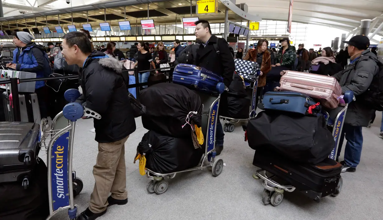 Para penumpang menunggu penerbangan yang tertunda di Terminal 4 Bandara Internasional John F Kennedy (JFK), New York, Senin (8/1). Sebelumnya, bandara mengalami rentetan penundaan akibat suhu ekstrem yang terjadi di wilayah timur laut AS (AP/Richard Drew)