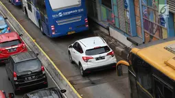 Kendaraan menerobos jalur transjakarta menghindari macet di Jalan MH Thamrin, Jakarta, Kamis (31/5). Tingginya antusiasme warga untuk berbuka puasa di rumah menyebabkan jalan-jalan protokol di Ibukota dipadati kendaraan. (Liputan6.com/Immanuel Antonius)