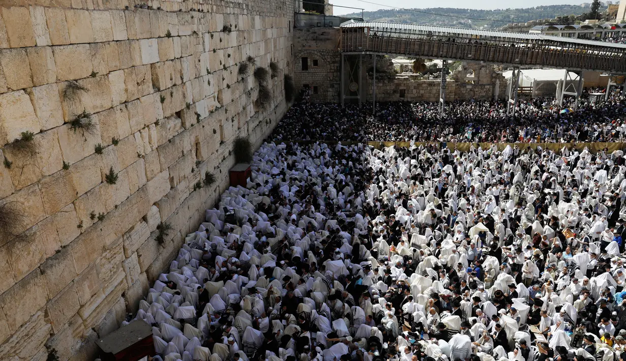 Ribuan umat Yahudi menggelar doa di Tembok Barat Kota Tua Yerusalem, Senin (2/4). Ritual memperingati penderitaan eksodus bangsa Israel dari Mesir ini berlangsung delapan hari selama libur Paskah. (MENAHEM KAHANA/AFP)