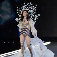 Model Tiongkok, Ming Xi berjalan di atas catwalk memperagakan koleksi lingerie pada Victoria’s Secret Fashion Show 2017 di Shanghai, Senin (20/11). Ming sempat tergelincir dan jatuh tersungkur di catwalk. (FRED DUFOUR/AFP)