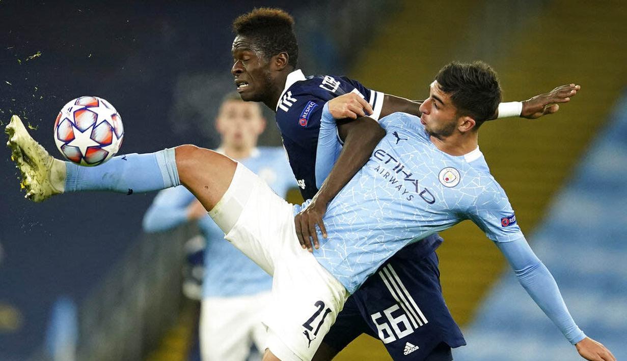 Penyerang Manchester City, Ferran Torres, berebut bola dengan pemain Olympiakos, Pape Abou Cisse, pada laga Liga Champions di Stadion Etihad, Rabu (4/11/2020). Manchester City menang dengan skor 3-0. (AP/Dave Thompson)