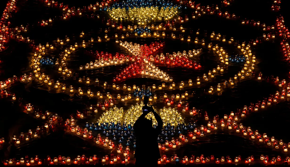 Pengunjung memotret pajangan lilin selama Festival Cahaya Cittadella, di Benteng abad pertengahan di Victoria, Pulau Gozo, Malta, (16/3). Sekitar 30 ribu lilin bertebaran di Victoria. (REUTERS / Darrin Zammit Lupi)