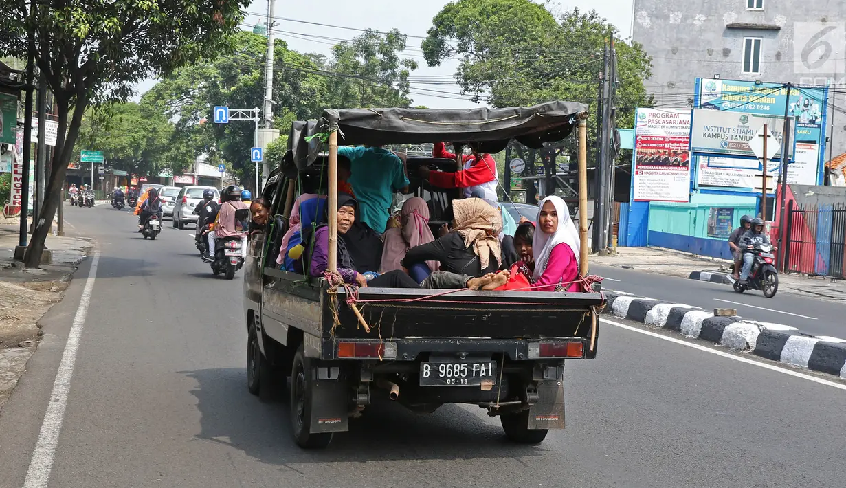 Sejumlah warga menaiki kendaraan bak terbuka saat bepergian libur lebaran menuju Kebun Binatang Ragunan di kawasan Jakarta, Minggu (9/6/2019). Warga memilih berpergian dengan mobil bak terbuka dan truk walau sangat membahayakan keselamatan mereka. (Liputan6.com/Herman Zakharia)