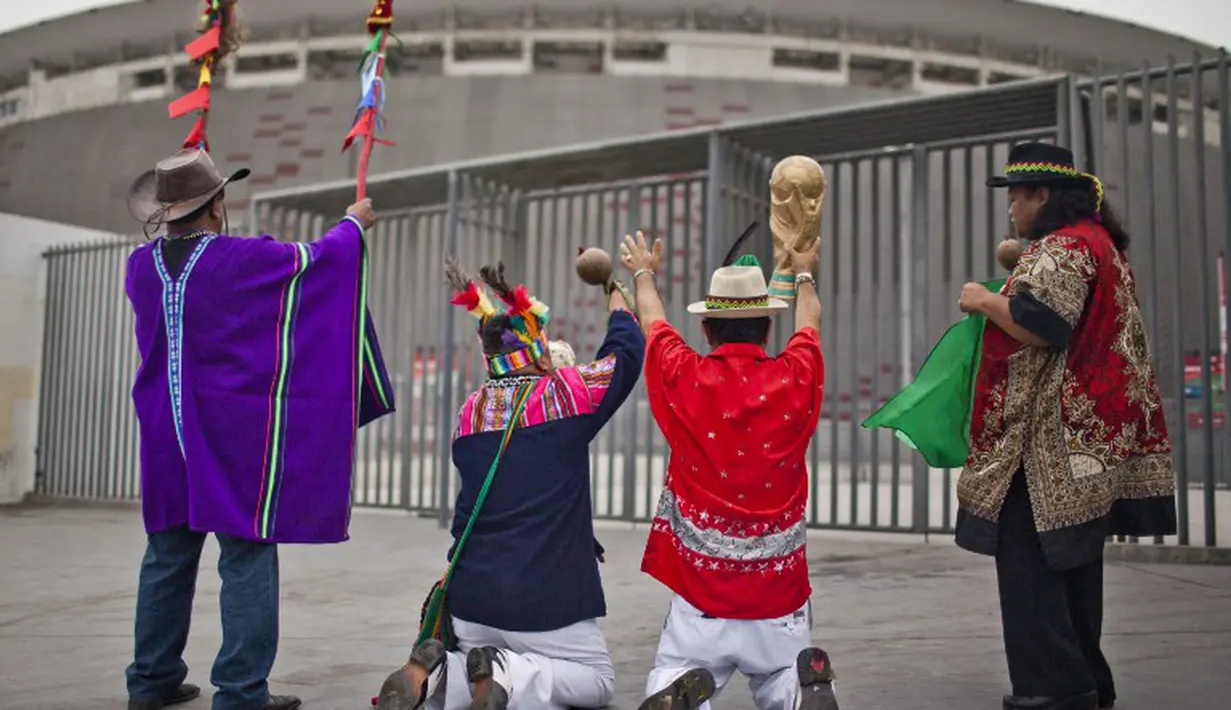 Para cenayang Peru melakukan aksi ritual perdukunannya di depan National Stadium of Peru , Selasa (10/06/2014) (AFP PHOTO/ERNESTO Benavides)