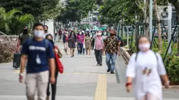 Suasana jam pulang kerja di jalur pedestrian kawasan Sudirman, Jakarta, Senin (22/6/2020). Pemprov DKI Jakarta menerapkan perubahan sif kerja untuk mengurangi kepadatan lalu lintas dan transportasi umum pada masa PSBB transisi. (Liputan6.com/Faizal Fanani).