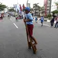 Sejumlah murid sekolah dasar (SD) bermain enggrang dalam festival  permainan tradisional rakyat Maluku didepan Balai Kota Ambon, Maluku, Senin (7/2). Festival tersebut diselenggarakan untuk memperingati Hari Pers Nasional. (Liputan6.com/Faizal Fanani)