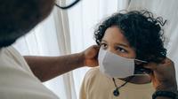 Ilustrasi memasangkan anak masker untuk melindungi diri dari paparan COVID-19. (Sumber foto: Pexels.com).